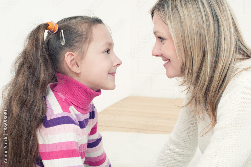 Mother and daughter smiling and looking at each other