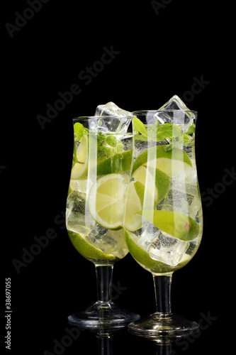 glasses of cocktails with lime and mint on black background