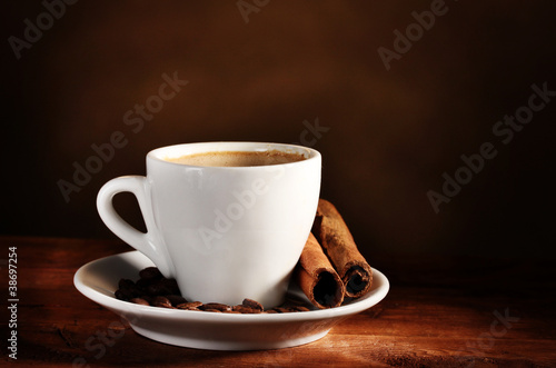 cup with coffee, cinnamon and coffee beans