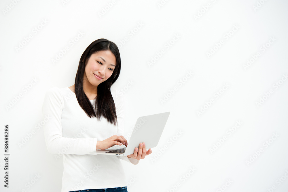 attractive asian woman using laptop in the white room attractive asian woman using laptop in the white room