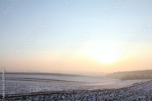 Sunrise over snow-covered field on a frosty January day