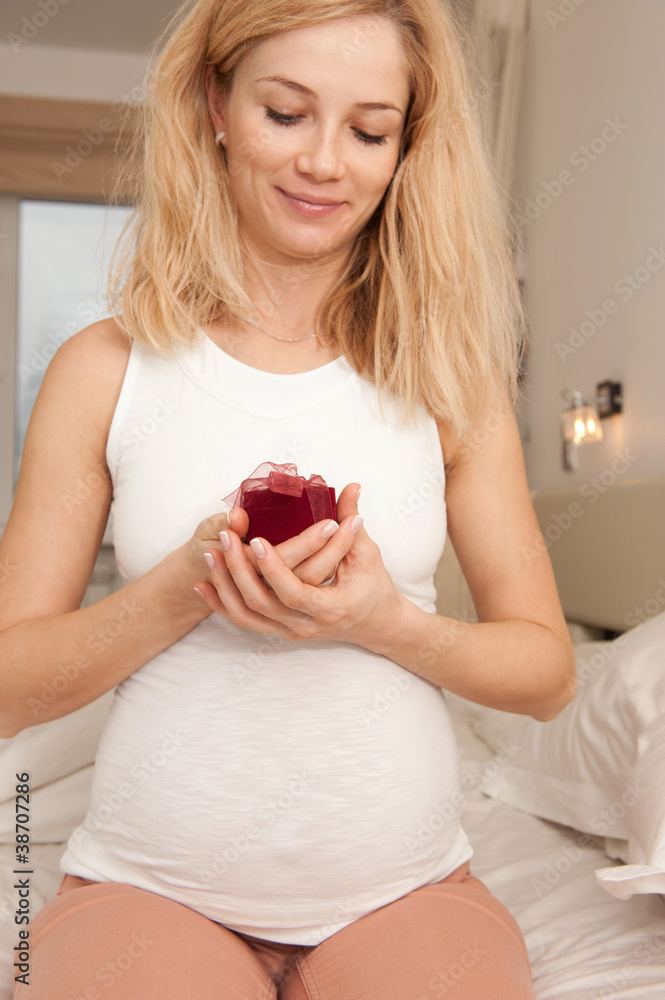 Surprised pregnant blonde with present box Surprised pregnant blonde with present box