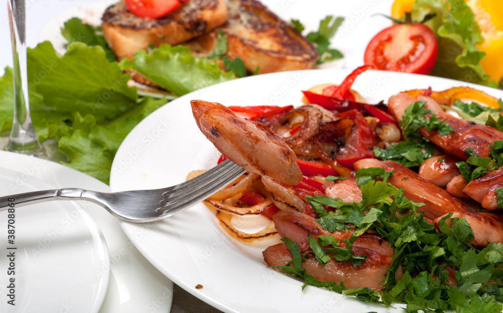 A fork with sausages and grilled vegetables A fork with sausages and grilled vegetables