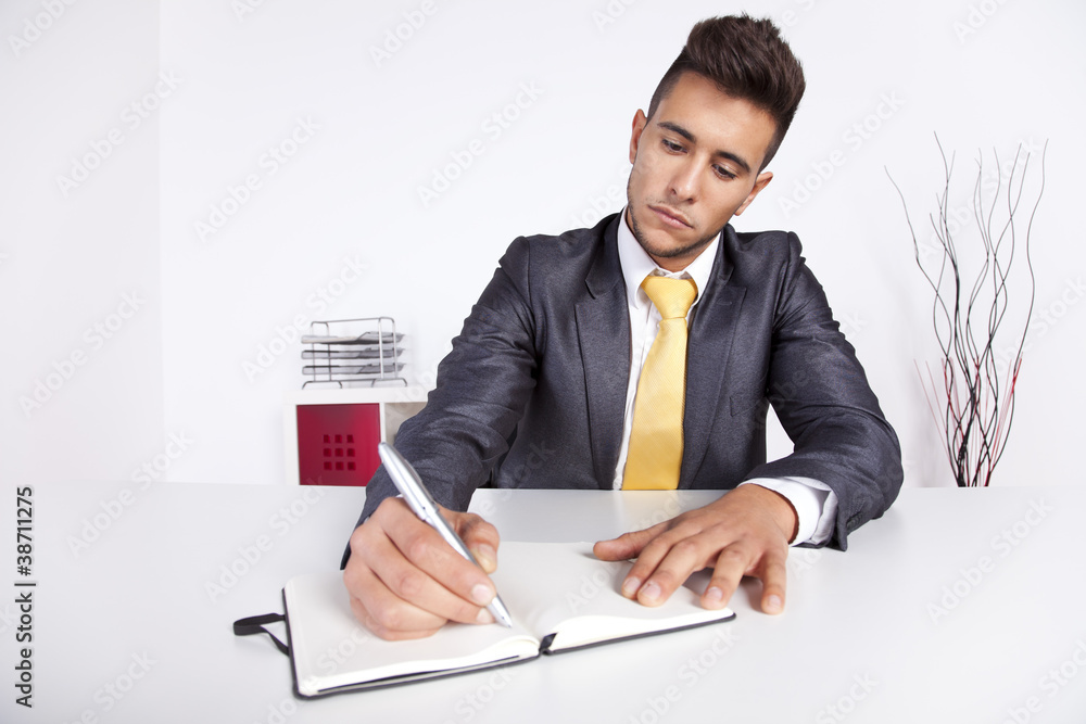 Businessman writing on the notepad Businessman writing on the notepad