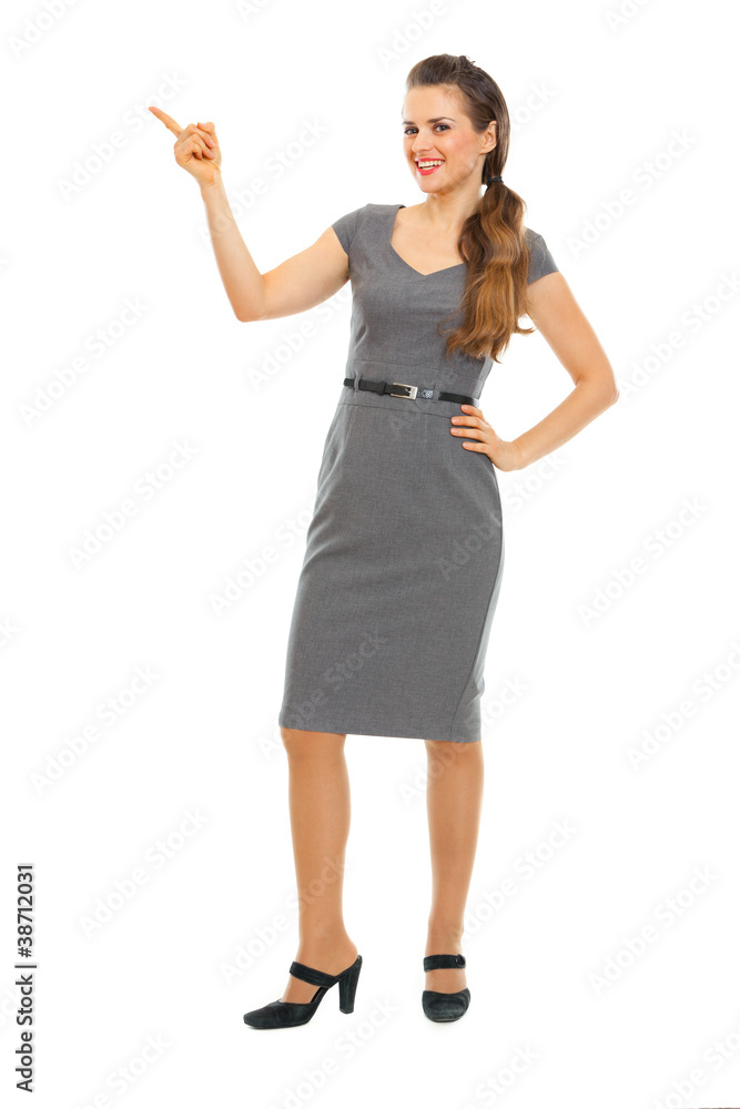 Full length portrait of business woman pointing in corner Full length portrait of business woman pointing in corner