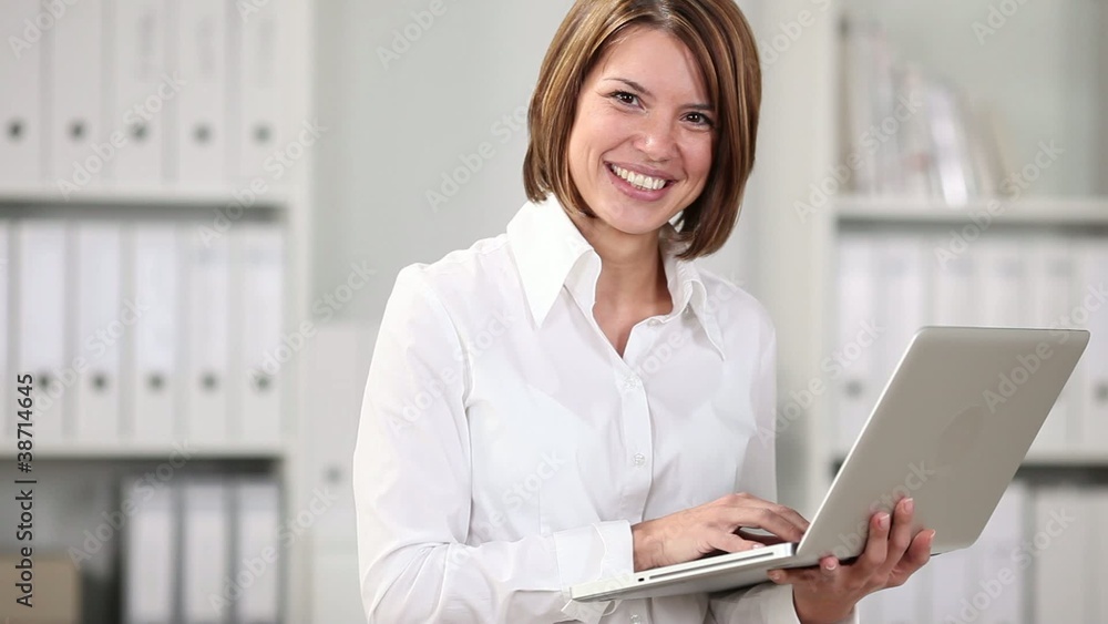 lächende junge frau arbeitet mit laptop im büro lächende junge frau arbeitet mit laptop im büro