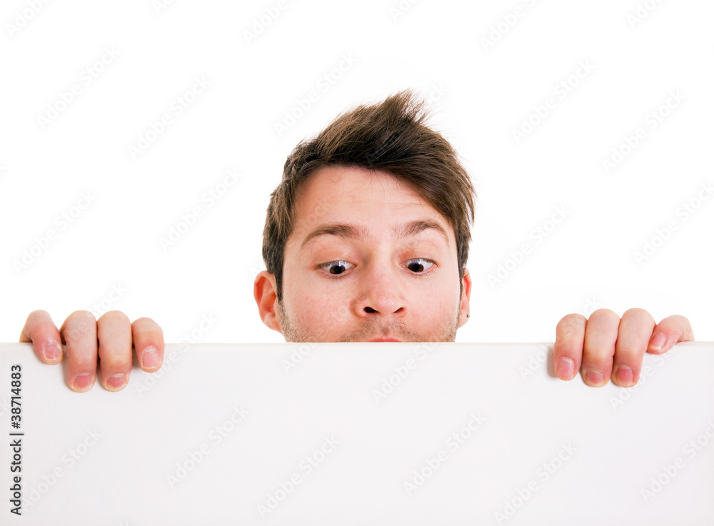 Young man holding a blank board and looking down. Isolated on wh Young man holding a blank board and looking down. Isolated on wh