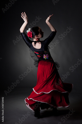 young woman dancing flamenco on black