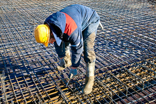 Foto Man worker installing binding wires to reinforcement steel bars