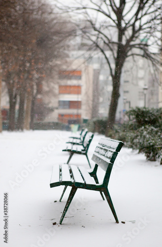 Winter in Paris. Benches in a park covered with snow
