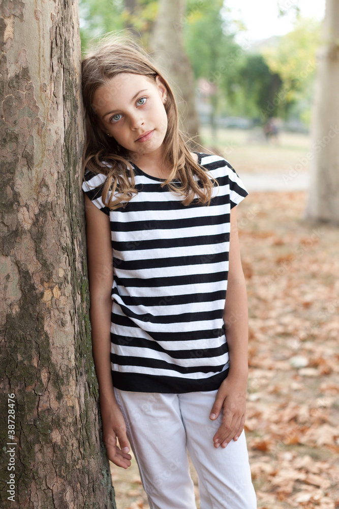 Young girl posing by the tree in the park Young girl posing by the tree in the park