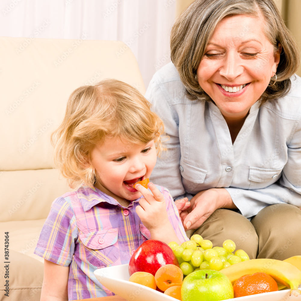 Little girl eat apricot fruit with grandmother Little girl eat apricot fruit with grandmother