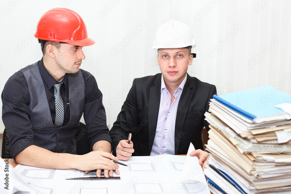 Architect and construction engineer discussing plan in office Architect and construction engineer discussing plan in office