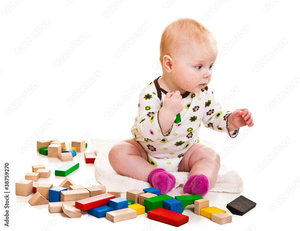 Infant girl playing with building bricks isolated on white Infant girl playing with building bricks isolated on white