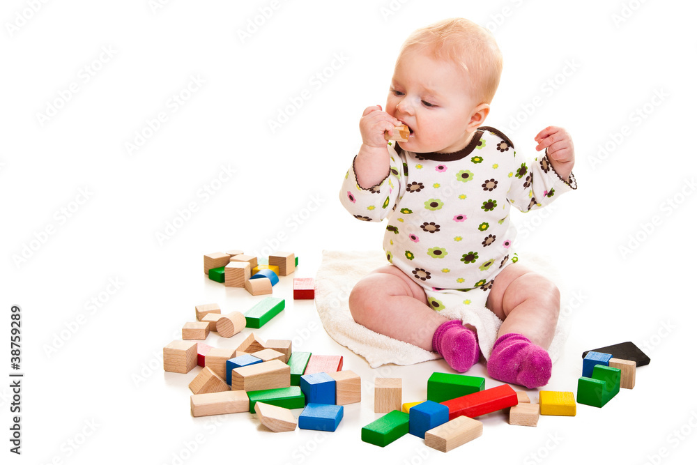 Infant girl playing with building bricks isolated on white Infant girl playing with building bricks isolated on white