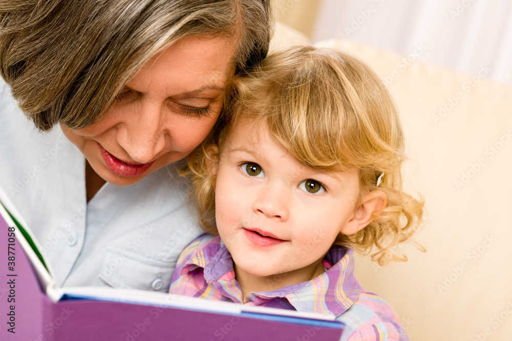 Grandmother and granddaughter read book together Grandmother and granddaughter read book together