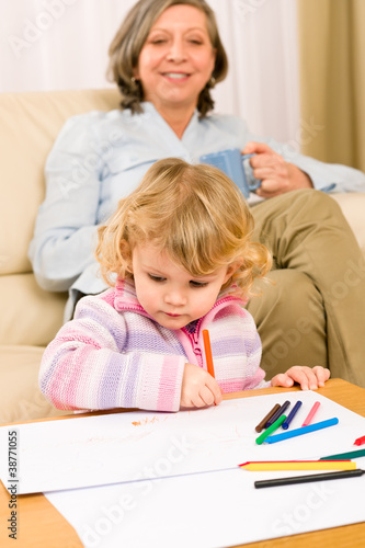Grandmother and granddaughter drawing at home