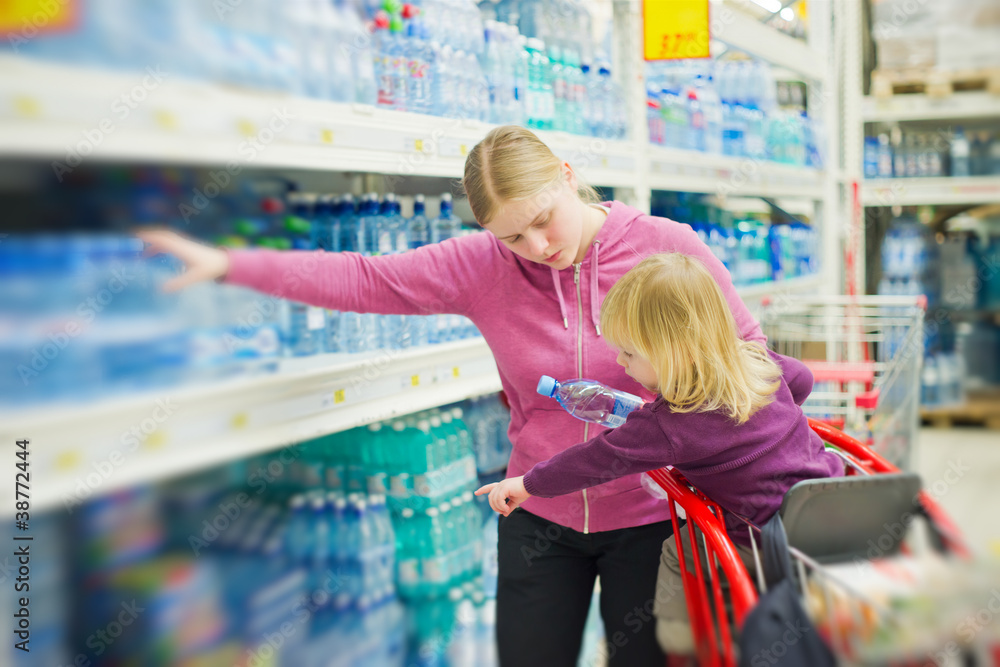mother and daughter in water section in supermarket