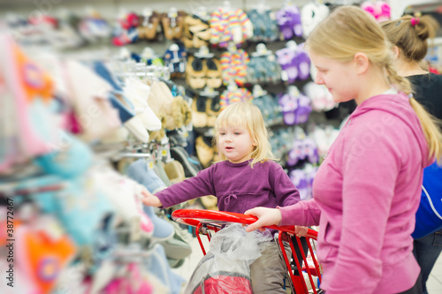 Mother and daughter in shoes section in supermarket