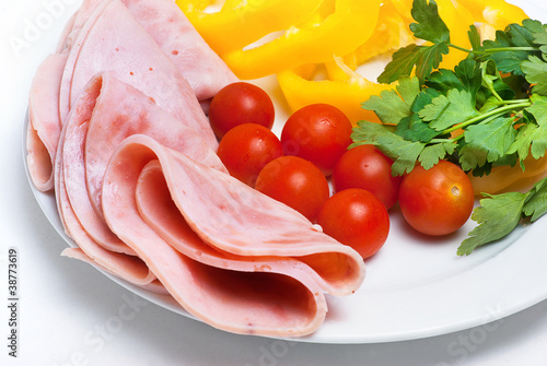 some ham slices on plate with tomatoes and parsley