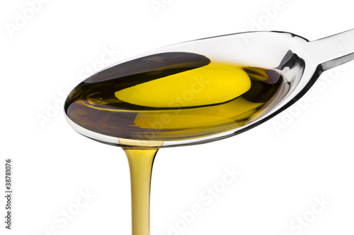 Olive oil poured from a spoon isolated on white