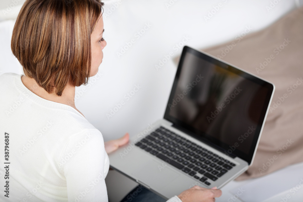 Fototapeta premium junge frau blickt auf laptop