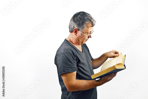 man with glasses reading in a book photo