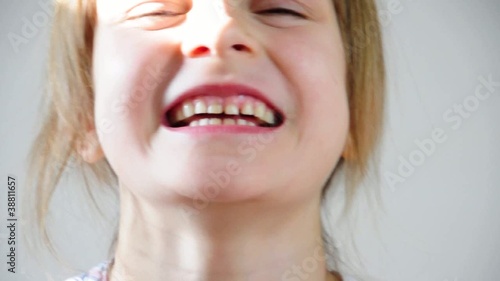 Close-up portrait of a happy little girl bursting in laugh