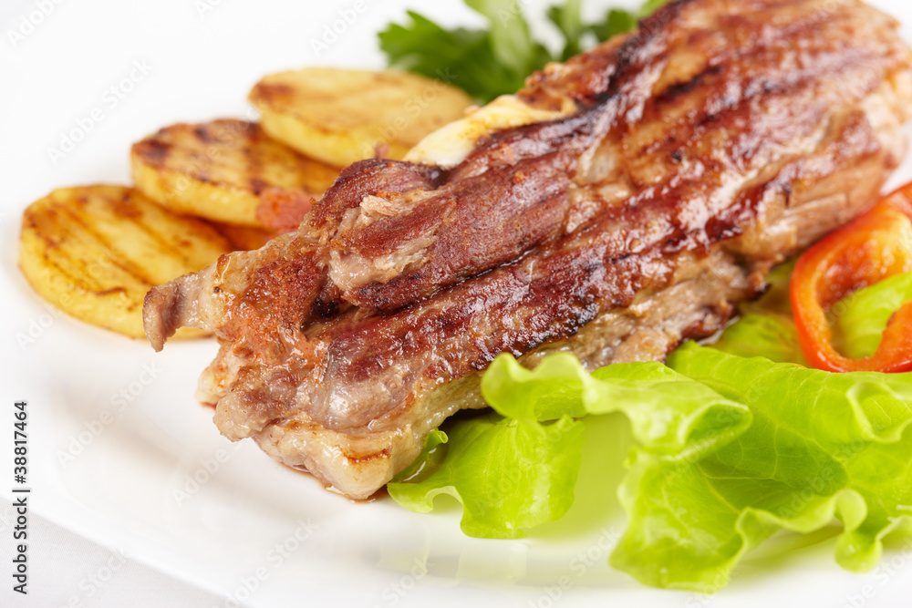 Grilled meat with vegetables on white plate Grilled meat with vegetables on white plate