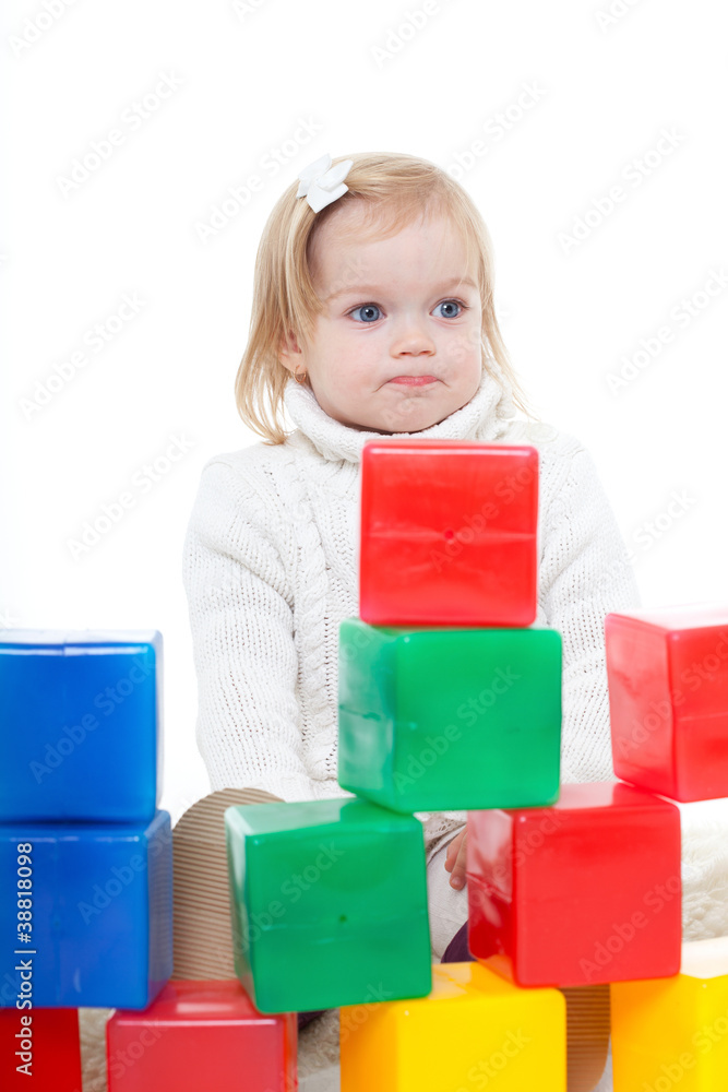 Baby girl plays with toy blocks over white background Baby girl plays with toy blocks over white background