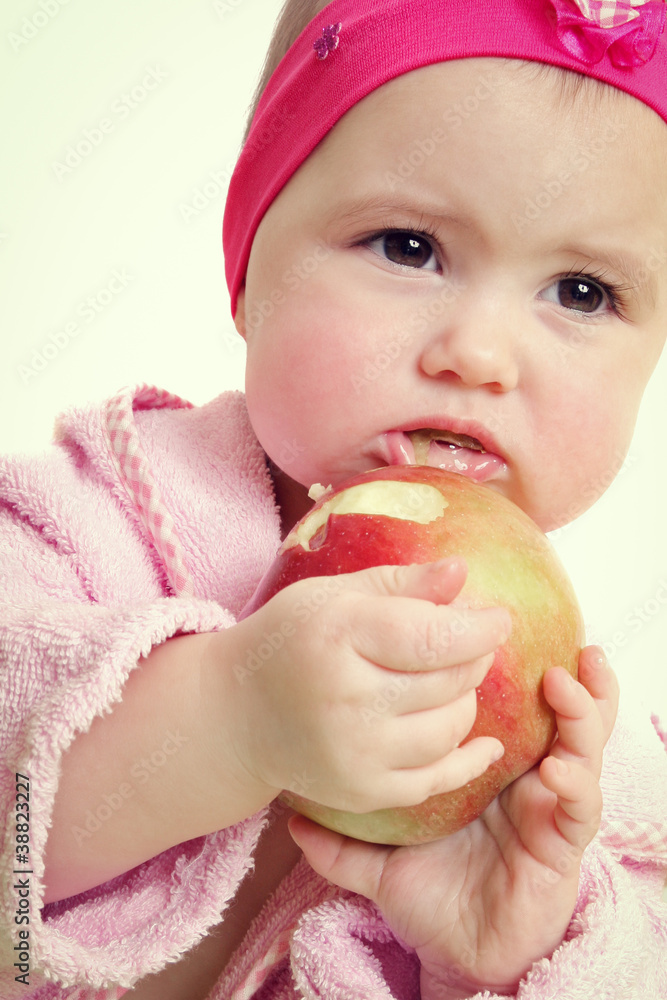 Baby holding and eating an apple, isolated on white Baby holding and eating an apple, isolated on white