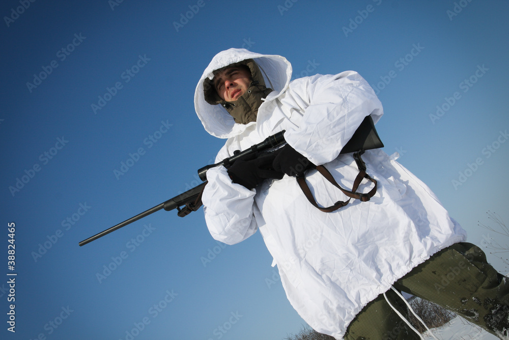 Hunter in white camouflage suit with sniper