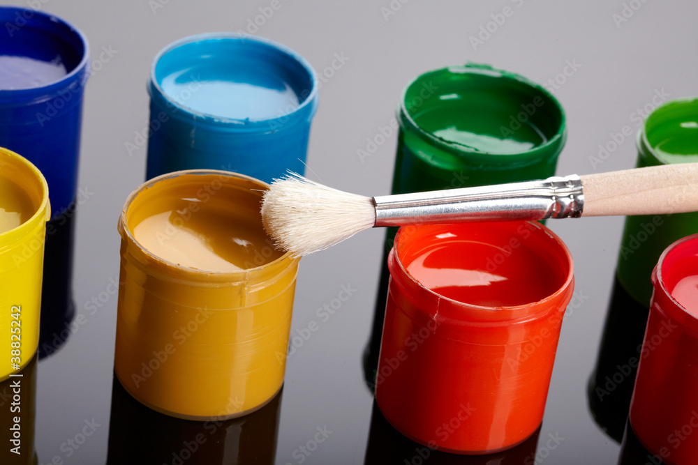 Paint buckets with paintbrush over dark background Paint buckets with paintbrush over dark background