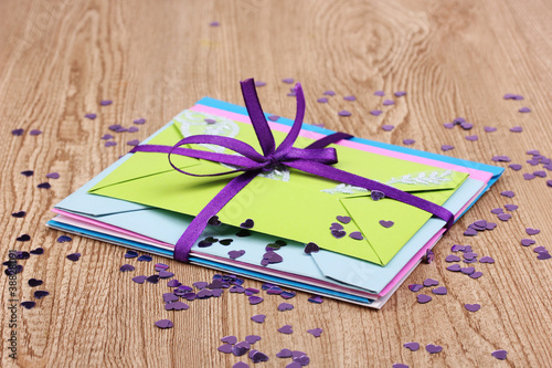 Bunch of color envelopes with ribbon and confetti