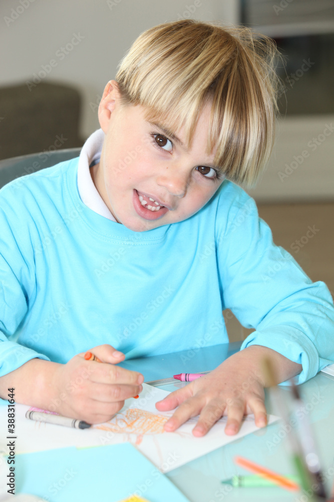 little boy drawing at school with wax crayons little boy drawing at school with wax crayons