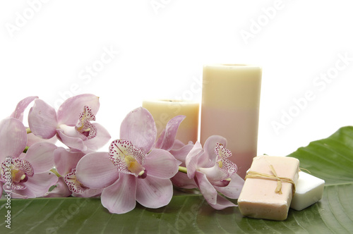 pink orchid and candle with soap on banana leaf