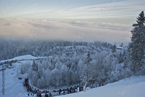 Crowd descending mountain into thick cold fog Fototapeta