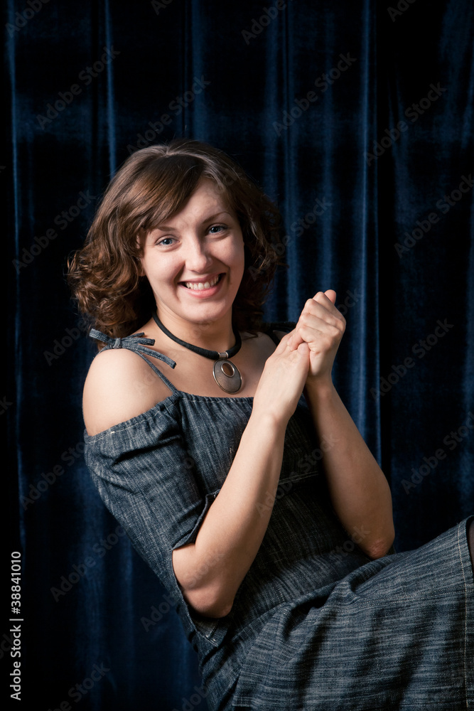 Portrait of young smiling woman on dark background