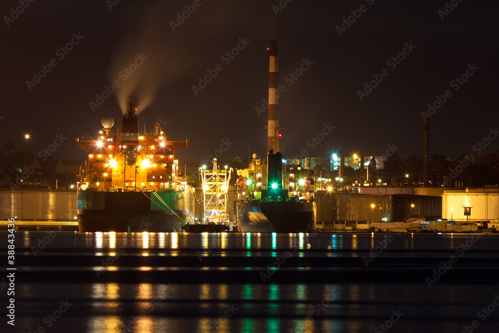 Fototapeta premium Oil tanker unloading cargo at night