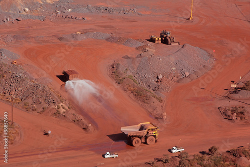 Foto Large, open-pit iron ore mine with trucks