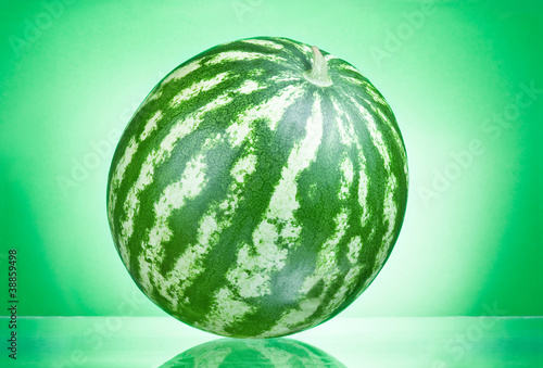 Single whole watermelon on a green background