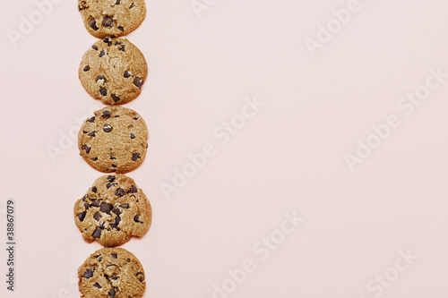ピンク色の背景に並べたチョコチップクッキー