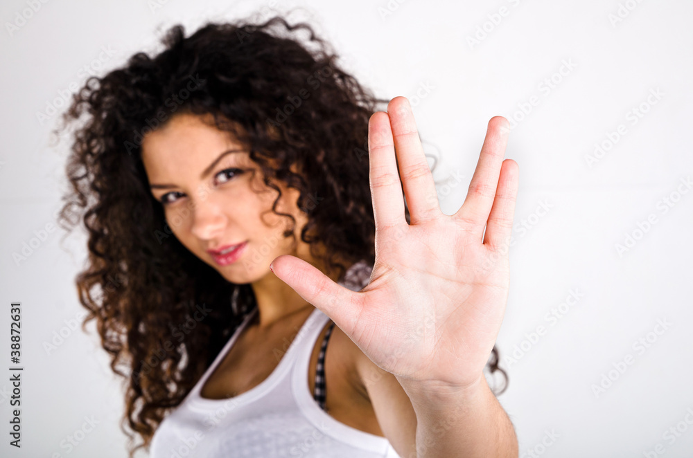 Сurly-haired girl in a white T-shirt shows the sign Сurly-haired girl in a white T-shirt shows the sign