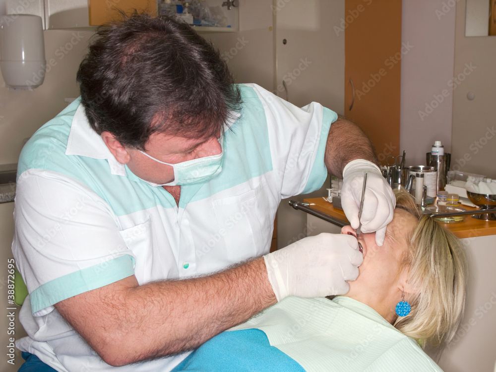 Dentist making filling to mature lady Dentist making filling to mature lady
