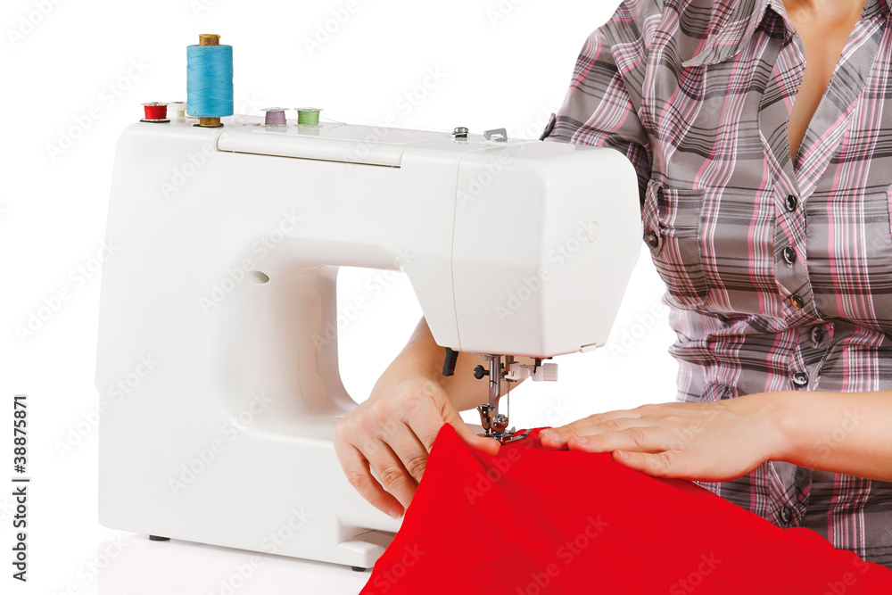 Woman is sewing on the sewing machine on a white background