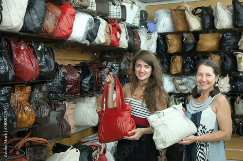 women chooses leather bag at shop