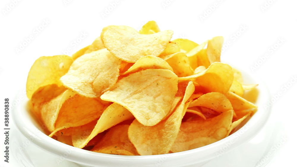 Potato chips heap rotating on a white plate, closeup view Potato chips heap rotating on a white plate, closeup view