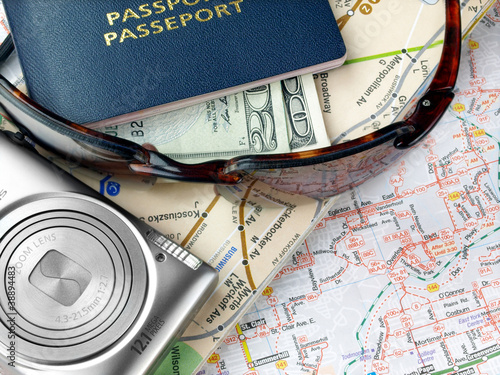Travel necessities: sunglasses, passports camera on the map