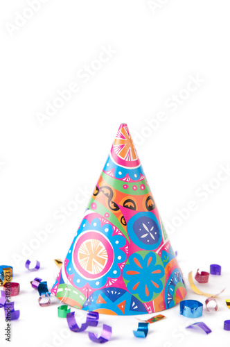 Bright party hat and confetti, isolated over white