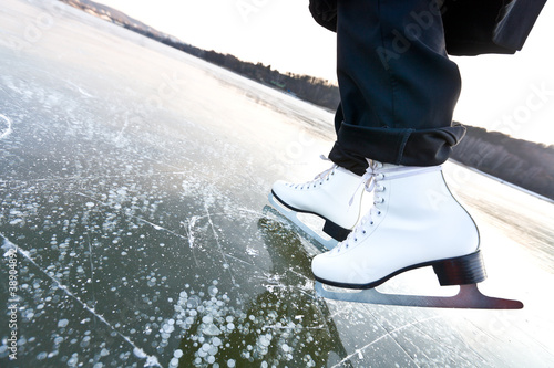 Woman ice skates with overview of a lake